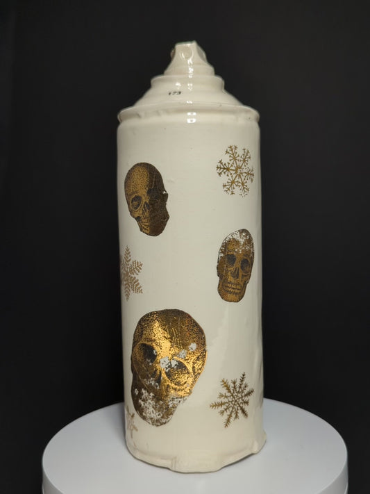video of ceramic spray rotating on base, can is by Adam Graddon, spraycan is cream ceramic with gold skulls