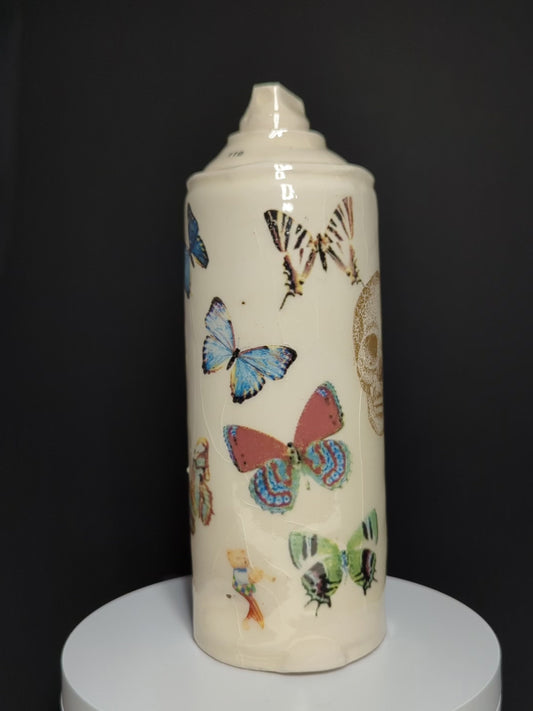 video of ceramic spray rotating on base, can is by Adam Graddon, spraycan is cream ceramic with colourful butterflies
