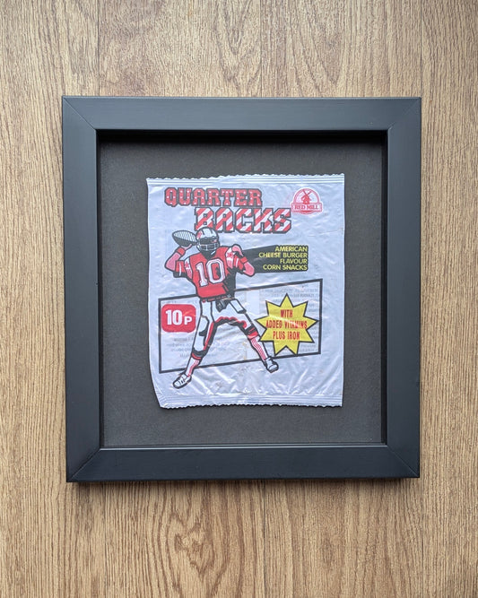 quarter back crisp packet in black frame on a wood background