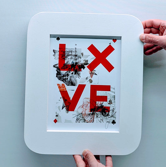 card game style love print, print is in a white picture frame with curved edges to replicate a playing card. frame is in fornt of a white background.