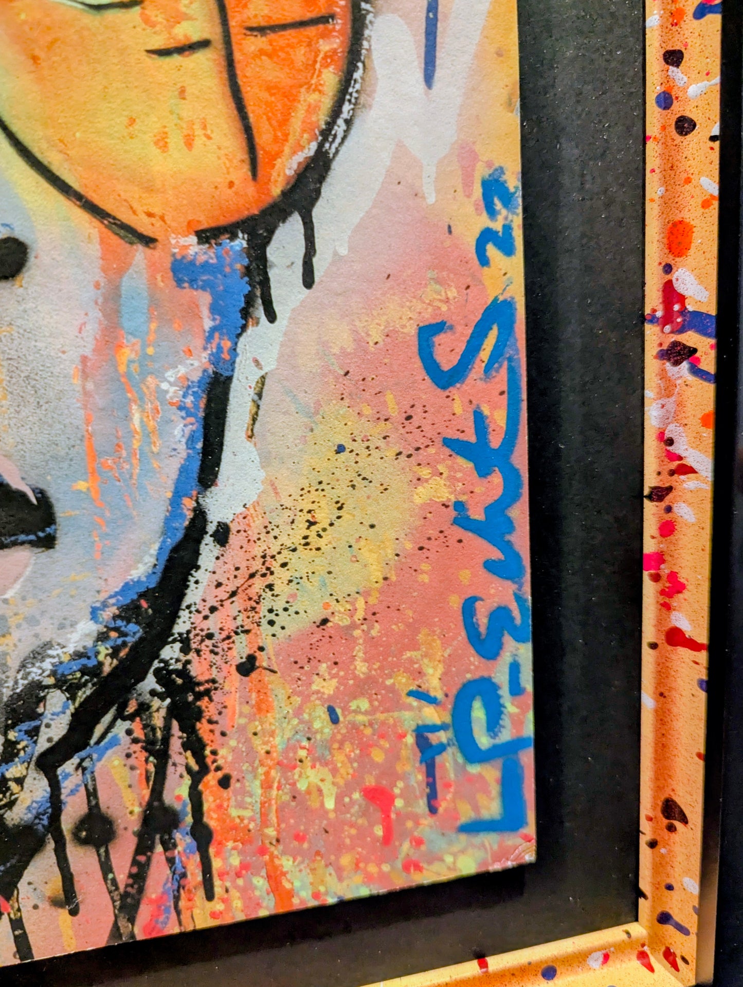 Abstract artwork with colorful splashes and a signature in blue.