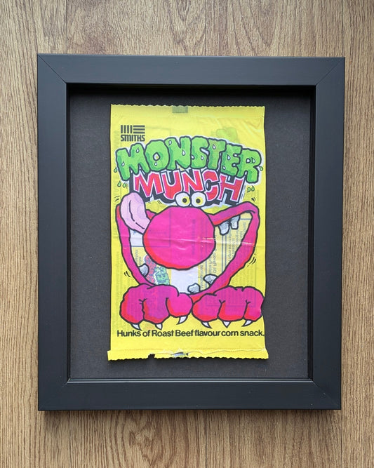 Framed vintage Monster Munch snack packet on a wooden surface