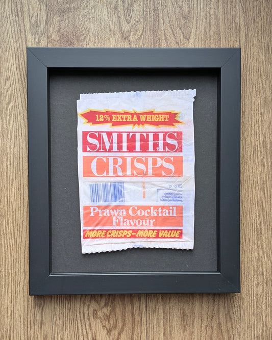 Framed Smiths Crisps packet on a wooden surface