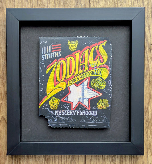 Framed vintage-style packaging of 'Zodiacs' corn and potato snack with colorful text and graphics.