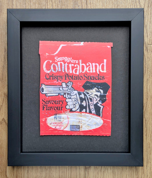 Framed artwork of a parody potato snack packet with a gun and 'Contraband' text.