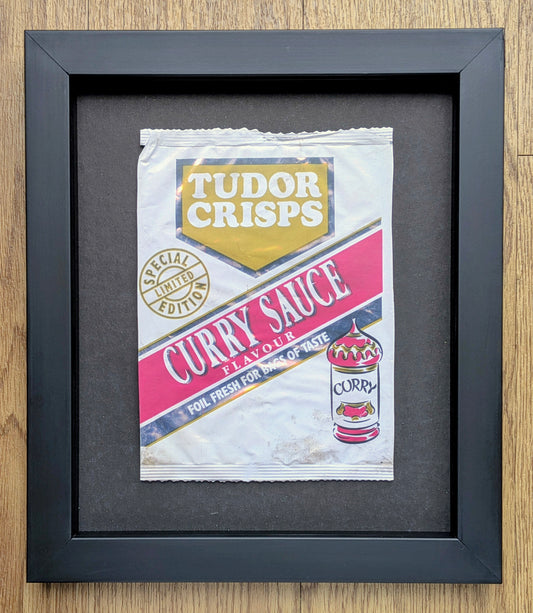 Framed Tudor Crisps Curry Sauce flavor packet on a wooden surface