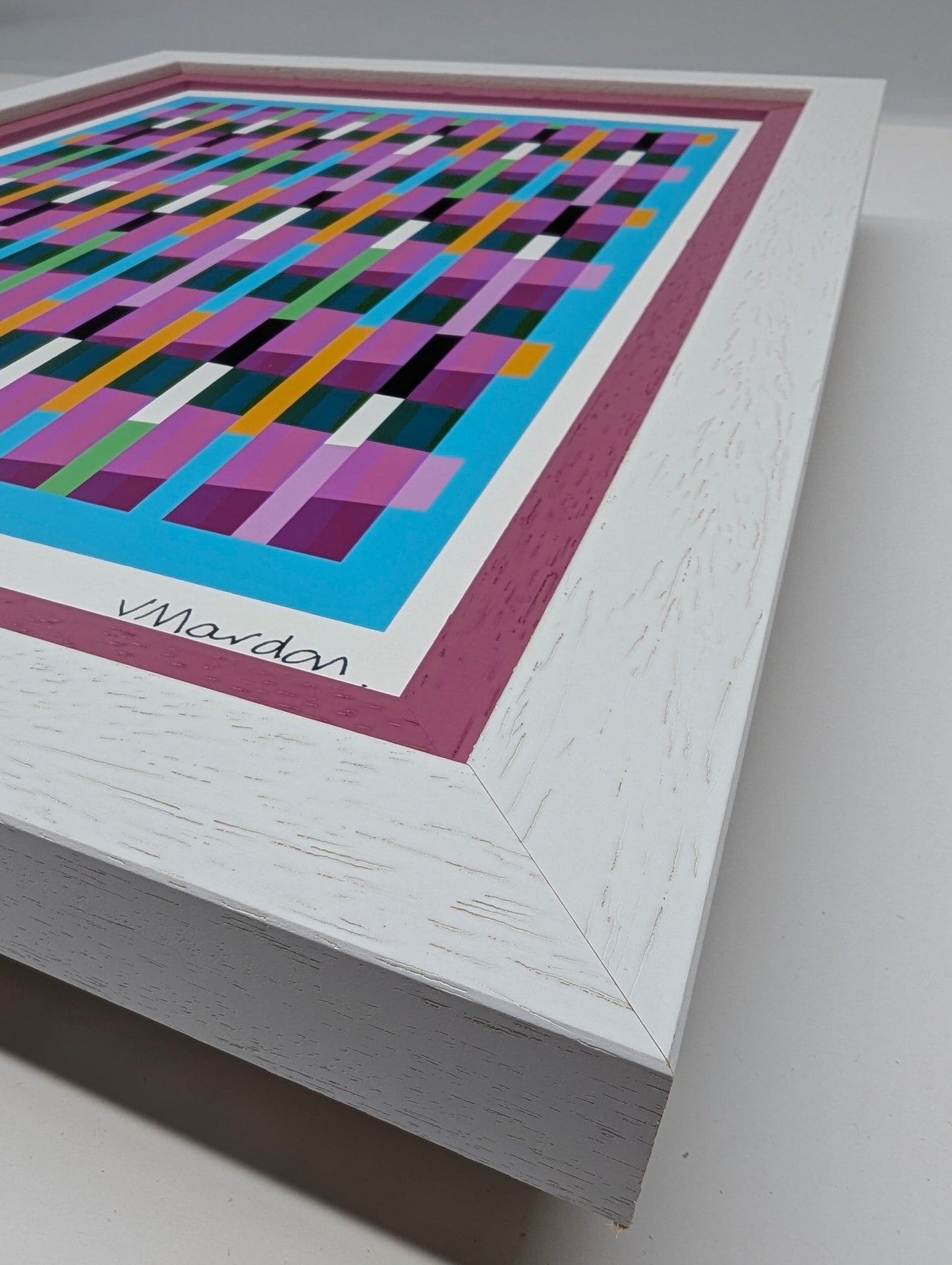 Framed abstract artwork with colorful geometric pattern on a gray background