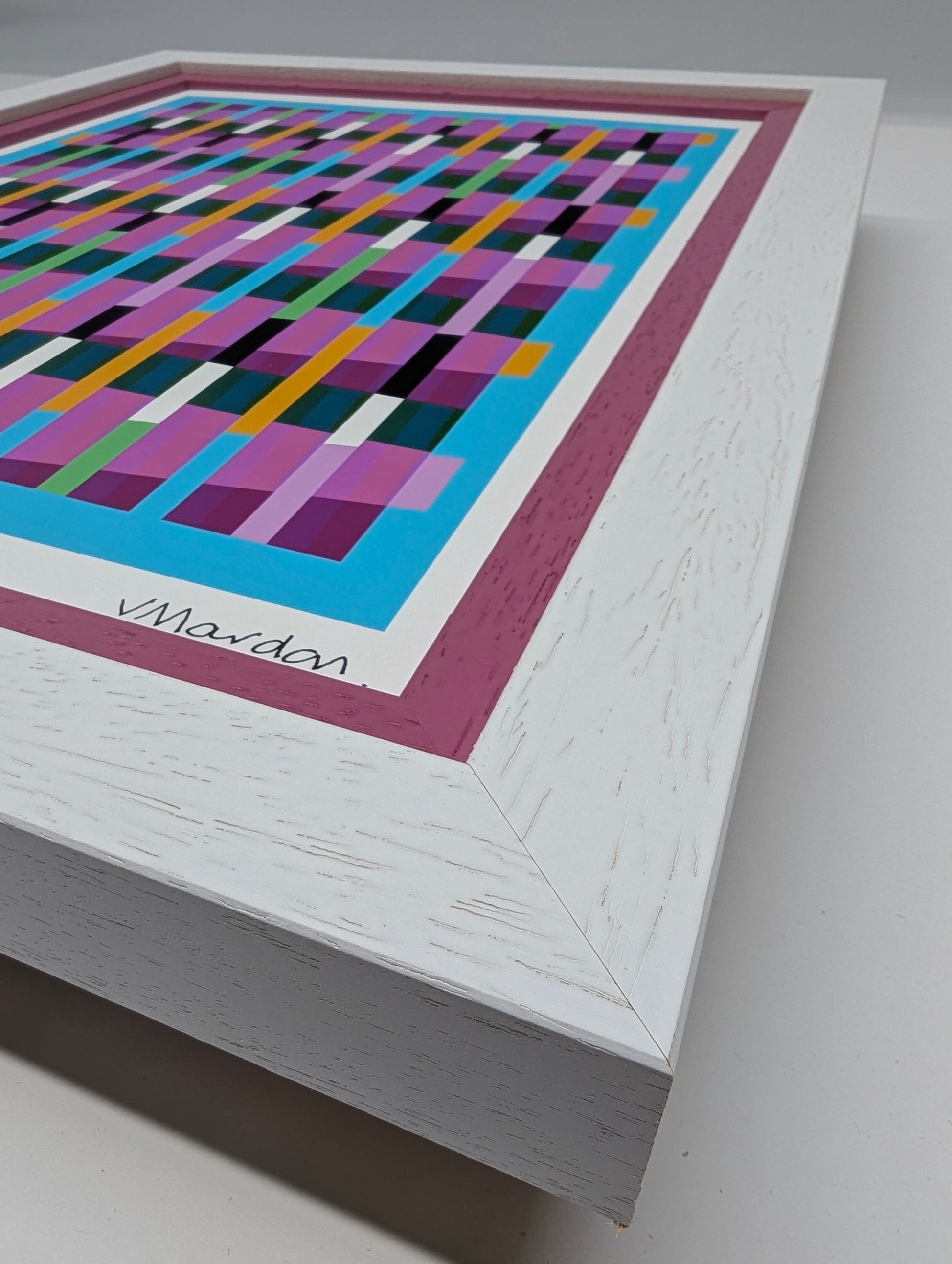 Framed abstract artwork with colorful geometric pattern on a gray background