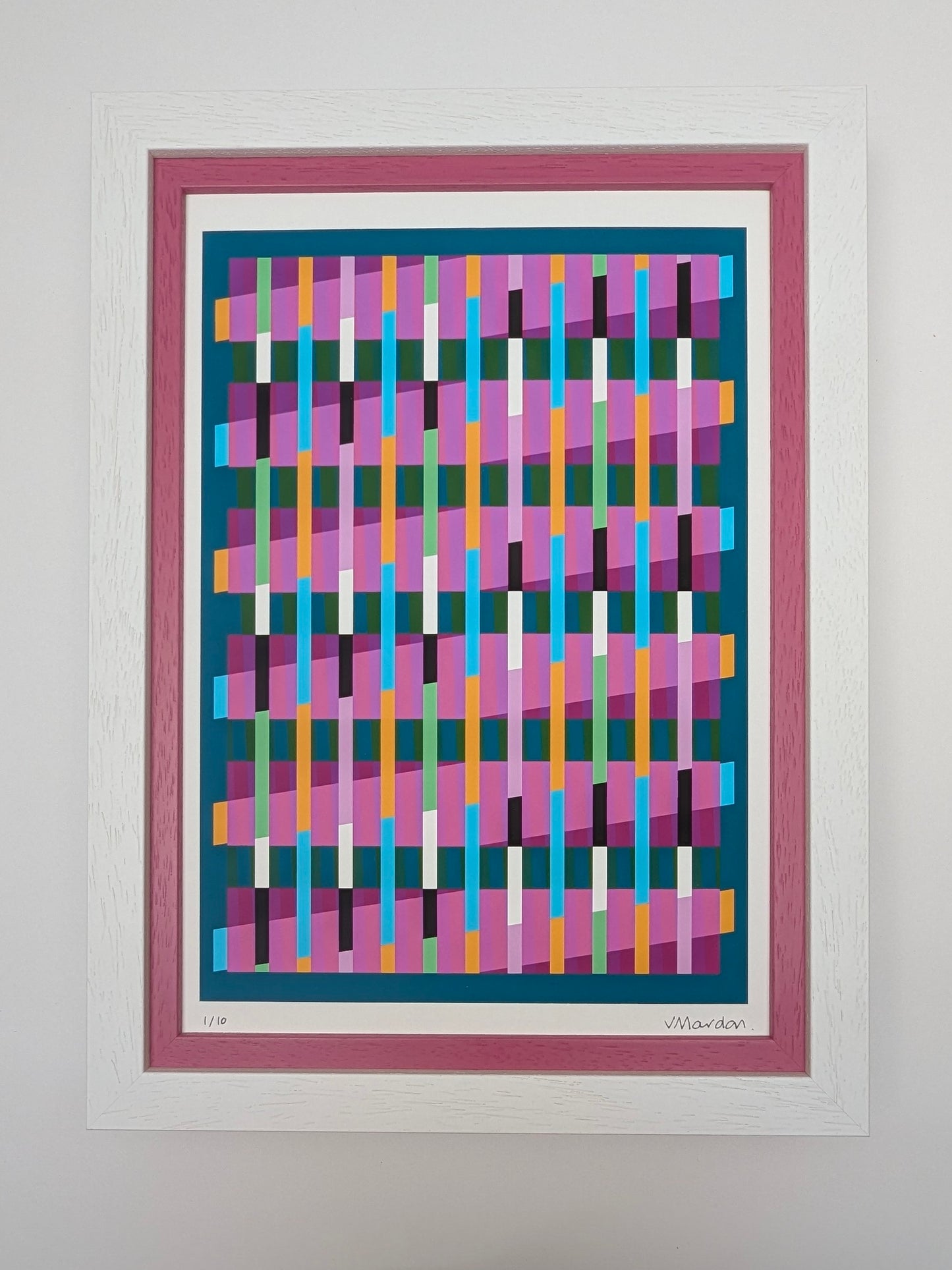 Framed abstract artwork with colorful geometric design on a white wall
