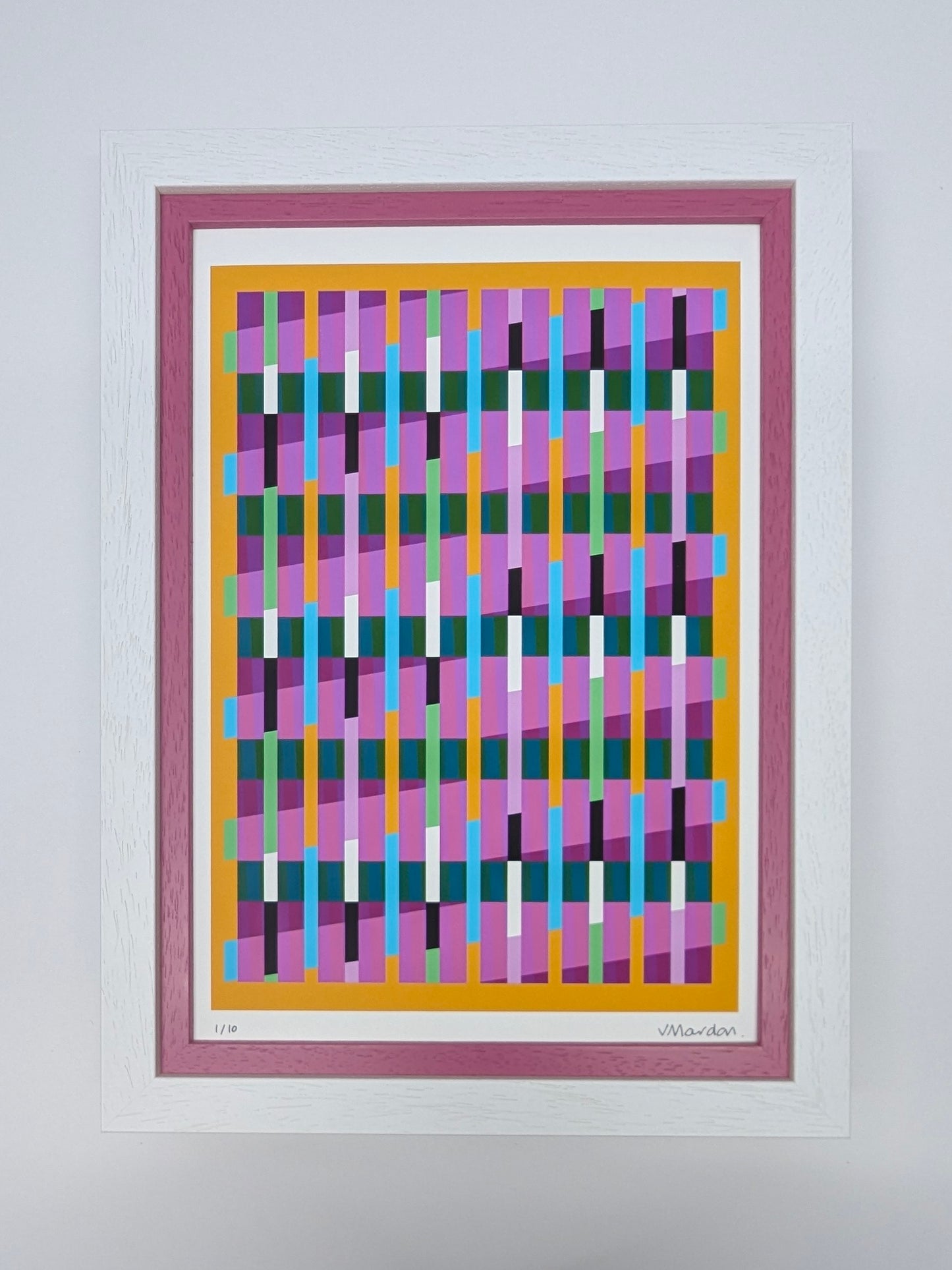Framed abstract artwork with colorful geometric design on a white wall