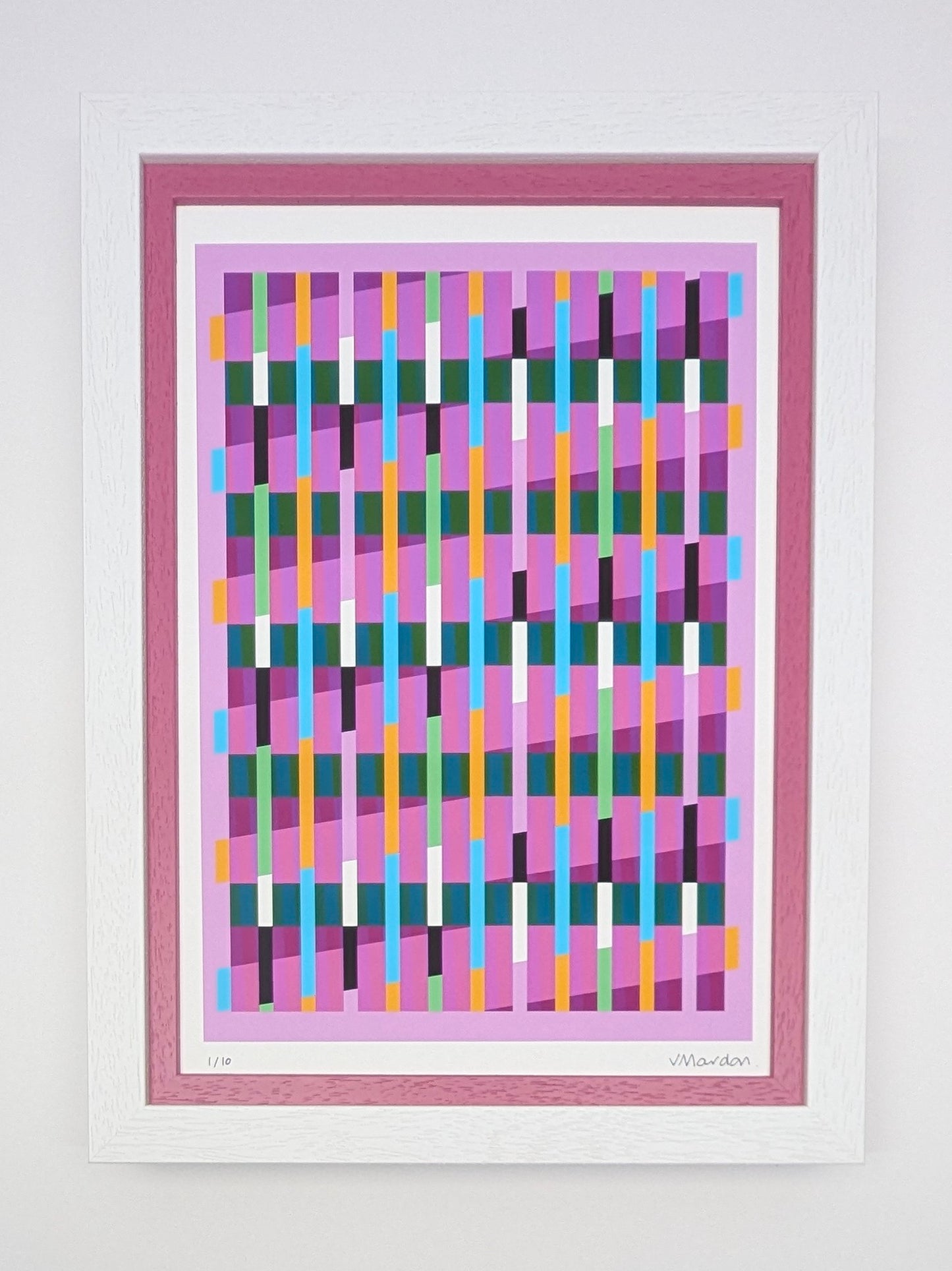 Framed abstract art print with colorful geometric design on a white wall