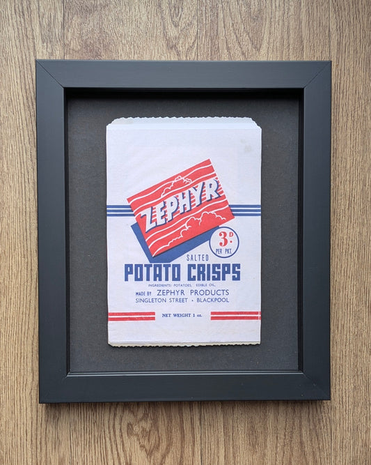 Framed Zephyr Potato Crisps packaging on a wooden surface